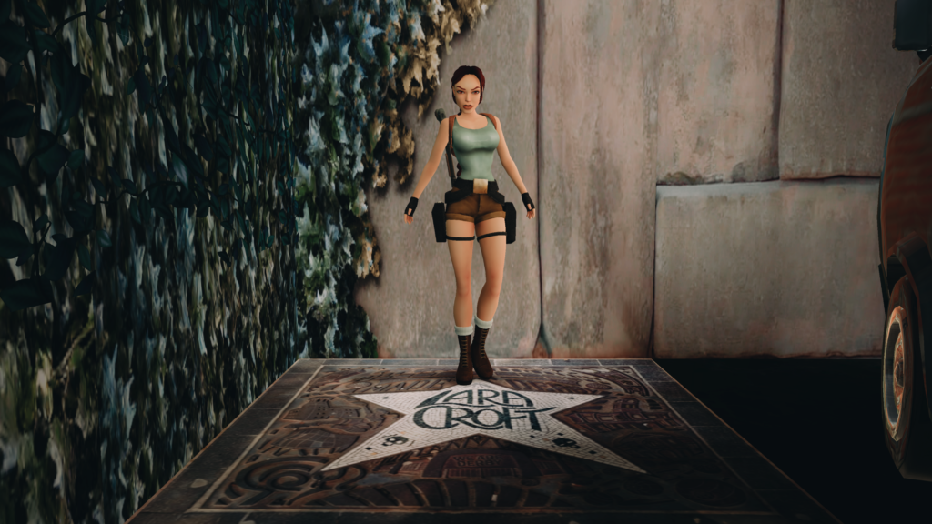 A screen grab from a Tomb Raider game, showing the character Lara Croft standing above a tiled star that has her name on it.